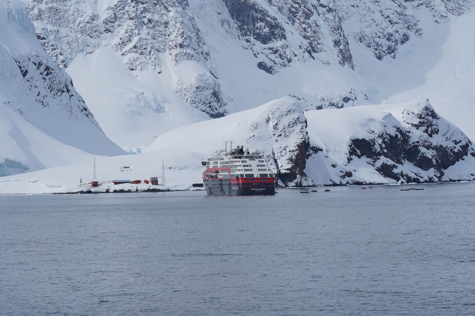 Small expedition ship among snow-covered mountains, one of the specialty cruises in the index