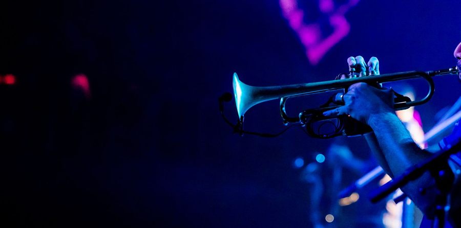 Trumpet player on stage under blue light