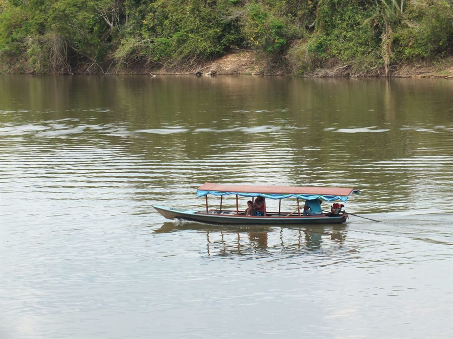 Long wooden boat on a wide river