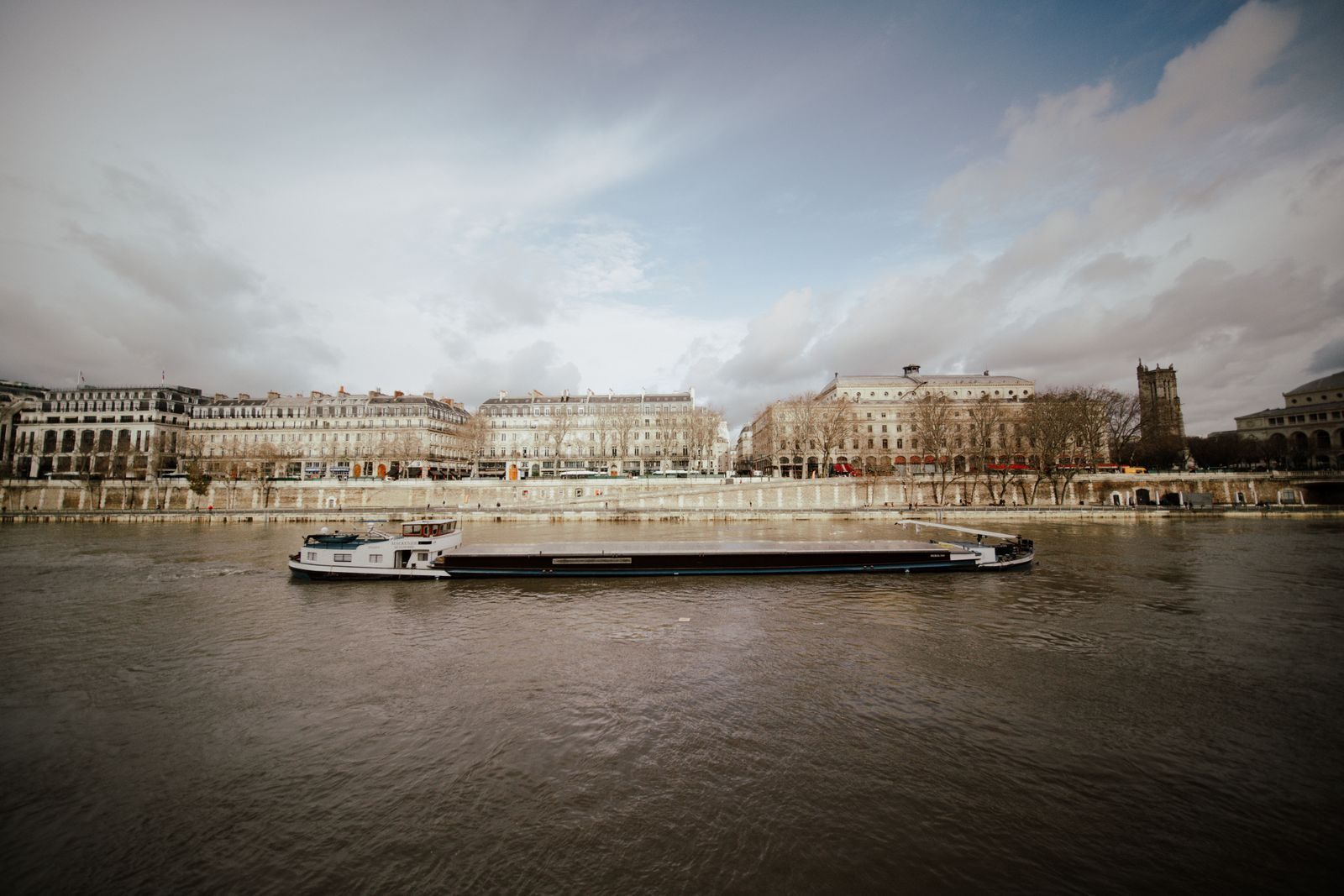 River cruise boat moored along a city riverbank, one of the types of cruises by ship